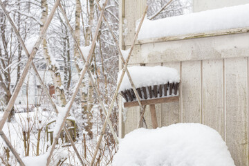 mop in the snow by a wooden fence for outdoor cleaning, upside down