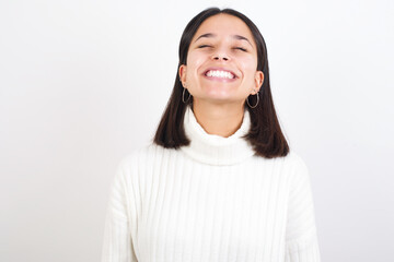 Young brunette woman wearing white knitted sweater against white background very happy and excited about new plans.