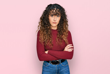 Young hispanic girl wearing casual clothes skeptic and nervous, disapproving expression on face with crossed arms. negative person.