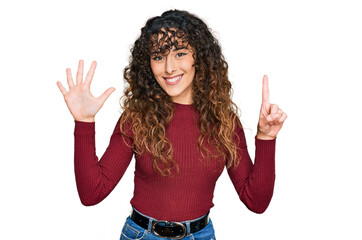 Young hispanic girl wearing casual clothes showing and pointing up with fingers number six while smiling confident and happy.