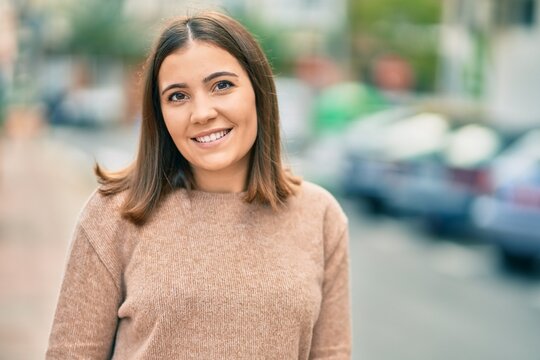 Young hispanic woman smiling happy standing at the city.