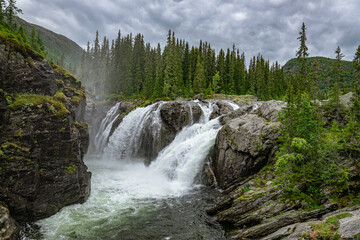 Rjukandefoss waterfall with dust and a rock