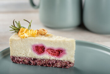 A piece of raw food cheesecake with strawberries on a gray plate.