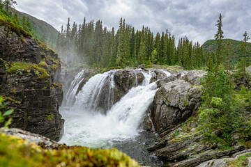 Rjukandefoss waterfall with dust and a rock