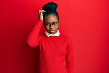 Young african american woman wearing casual clothes and glasses confuse and wonder about question. uncertain with doubt, thinking with hand on head. pensive concept.