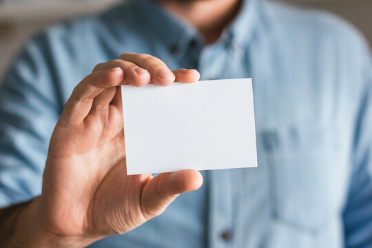 Blank paper business card mockup held by a businessman. Branding design template concept
