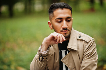 Stylish kuwaiti man at trench coat.