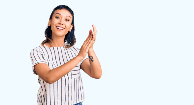 Young woman wearing casual clothes clapping and applauding happy and joyful, smiling proud hands together