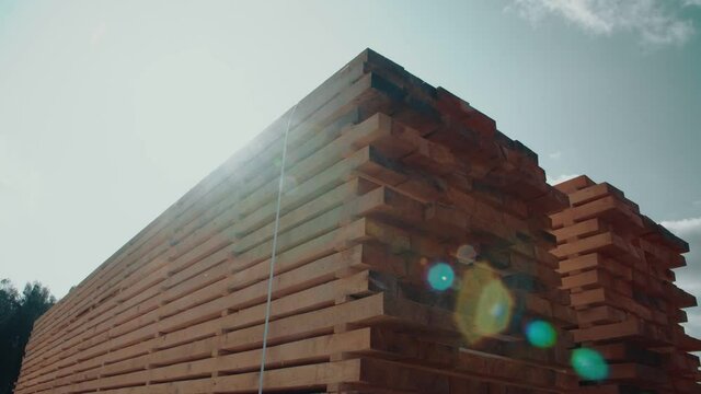Warehouse for sawing wooden planks at a sawmill outdoors. Sawmill, sawmill. Storage of planed wooden boards. Piles of wooden boards at a sawmill. Boards.