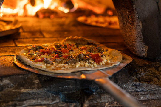 close up on pizza going to the wood oven, short depth of field