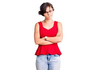 Beautiful young woman with short hair wearing casual style with sleeveless shirt skeptic and nervous, disapproving expression on face with crossed arms. negative person.