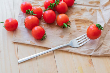 Naklejka na ściany i meble Cherry tomatoes. Tomato on a fork on kraft paper.