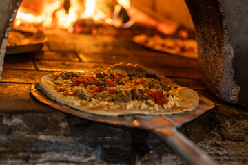 close up on pizza going to the wood oven, short depth of field