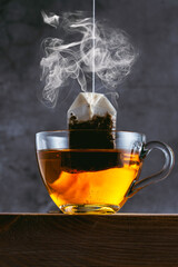 Herbal tea bag and vapor on black background
