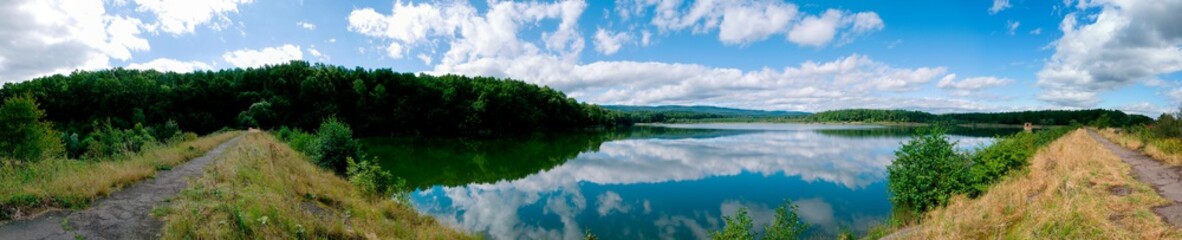 Panoramic view of a calm lake on a sunny summer day