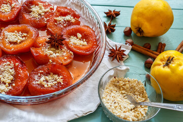 Quince dessert, fresh quince and spices on the green wooden table.