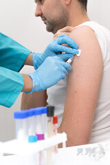 Medical worker vaccinates a middle-aged man in the arm in a medical office.Medicine and healthcare concept.Coronavirus vaccination concept.