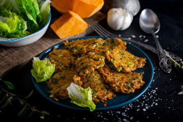 Vegetable patty with pumpkin, onion and dill. Pumpkin fritters on black background.