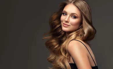 Keuken foto achterwand Schoonheidssalon Beauty blonde girl with long  and   shiny wavy  hair .  Beautiful   woman model with curly hairstyle . Fashion, cosmetics and makeup