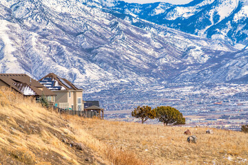 Snowy Wasatch mountain and valley viewed from hill terrain with brown grasses