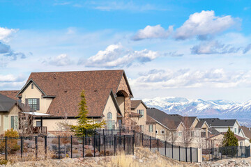 Fototapeta na wymiar Homes in Utah Valley neighborhood against snowy mountain and cloudy blue sky