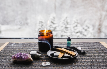 Palo Santo wood known as oily aromatic holy wood sticks smouldering on plate on home window sill...