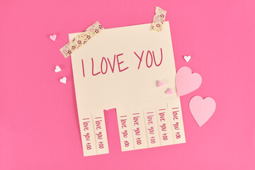 Valentine's day tear off stub note with text 'I love you' and reply 'I love you too' on pink...