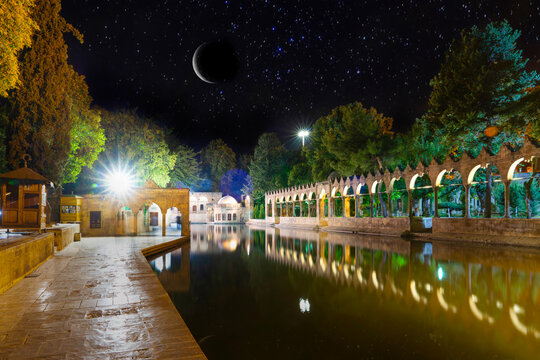 Sanli Urfa, Turkey: September 12 2020:  Halil-ur Rahman Mosque and Holy lake in Golbasi Park at night under crescent and stars