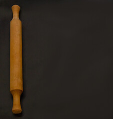 Rolling pin and white flour on a dark background. Cooking