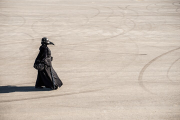 plague doctor alone on a large paved area