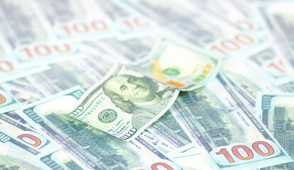 American hundred dollars are spread out on the table.