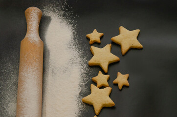 Obraz na płótnie Canvas flour and Christmas cookies on a dark background