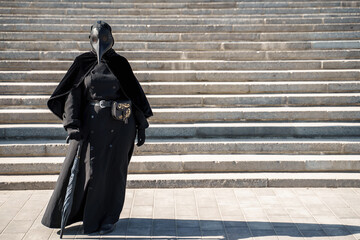 plague doctor in front of the stairs to the top