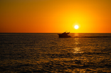 Silhouette of motor yacht on Mediterranean sea at sunset