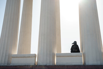 plague doctor stands between columns