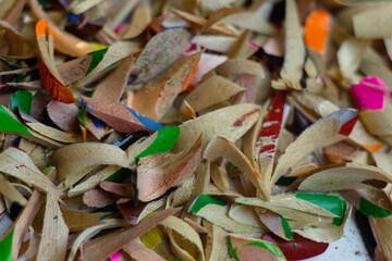 Shavings of colored pencils on a white background. Macro shooting.