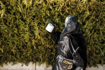 plague doctor holds toilet paper on a background of plants