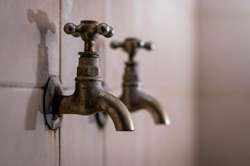 old bronze hot and cold water taps embedded in the wall cordoba argentina