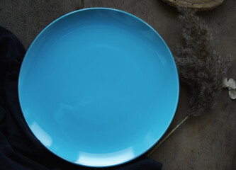 blank blue large plate on dark background to insert or attach your product