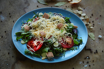 salad mix with avocado tomatoes with grated cheese and croutons on an empty dark background