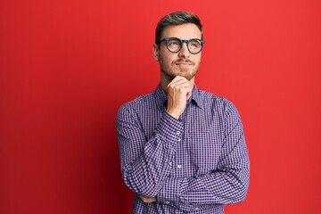 Handsome caucasian man wearing business shirt and glasses thinking concentrated about doubt with...