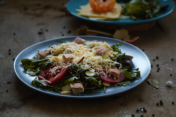 salad mix with avocado tomatoes with grated cheese and croutons on an empty dark background