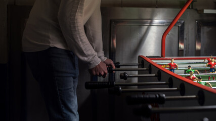 Un hombre jugando a fútbol de mesa en un bar. Futbolín, futbolito, metegol, fulbito, futmesa. © AliciaFdez
