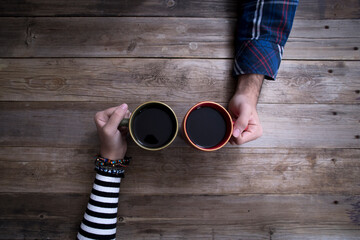 hands holding many colorful cups of coffee