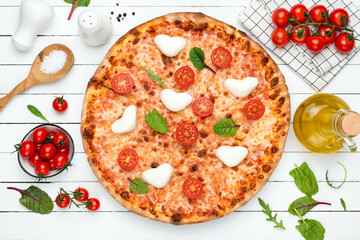 Italian pizza with tomatoes and mozzarella cheese on white wooden table background, top view