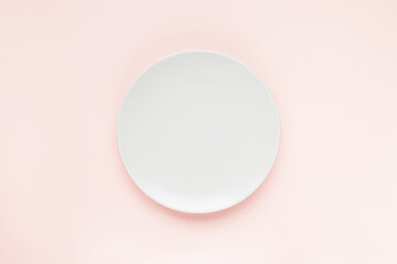 Empty plate on pastel pink minimalistic background. Cooking, meal, dinner, menu and recipe concept. Top view, flat lay, copy space