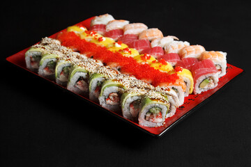 Asian cuisine dish, delicious sushi, sushi on a black background, roll you net on a black background