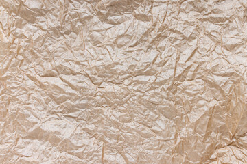 Crumpled brown kraft paper for gift wrapping or packaging. Close up, texture background, polution and recycling concept