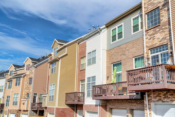 Exterior of townhouses with attached garages and stone brick and wall siding