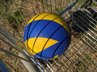 the volleyball lies in a metal grid